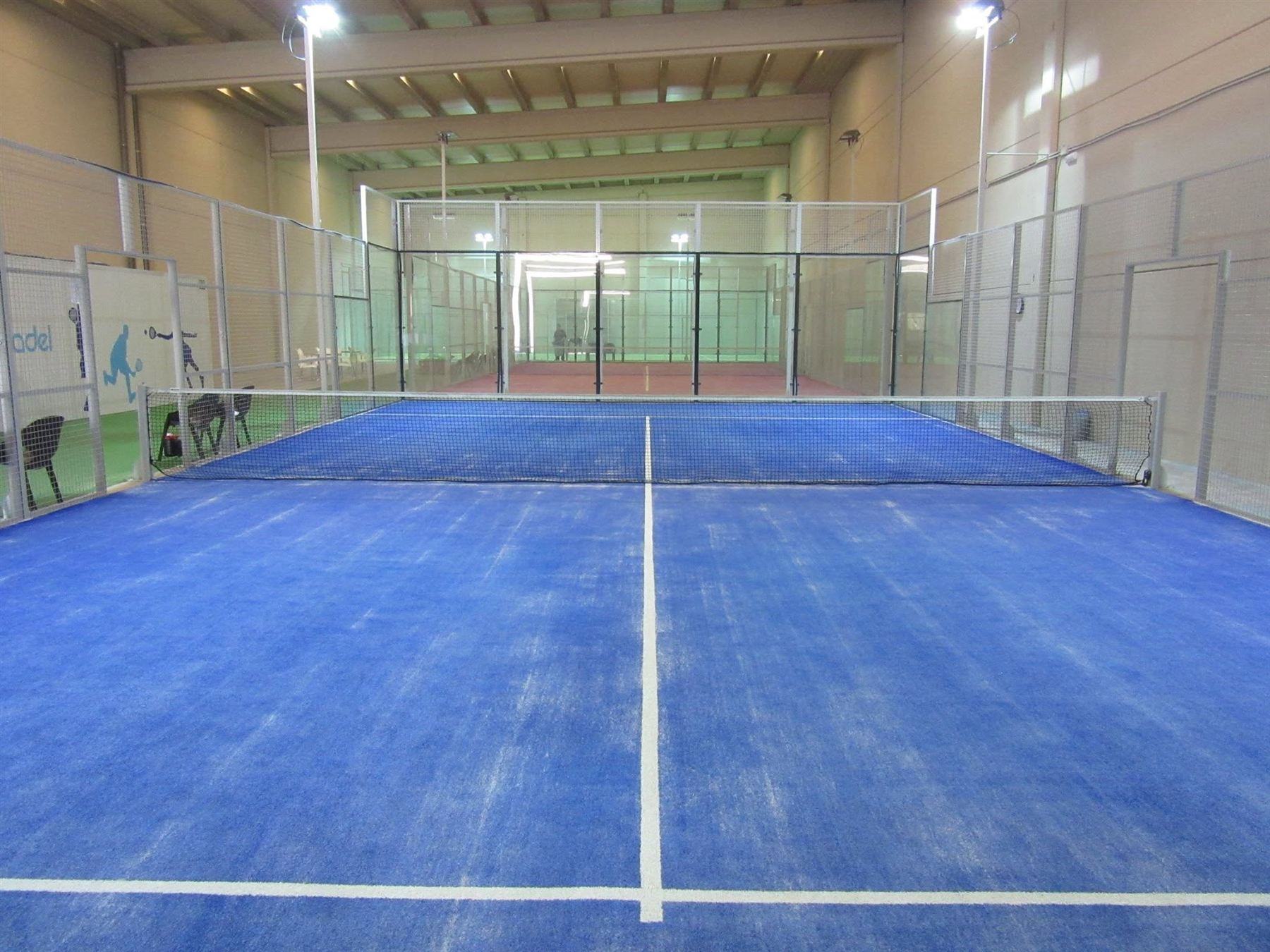 Pista azul con red, cristal y focos
